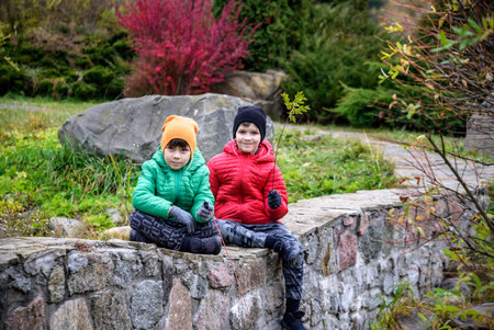 Close up portrait two happy positive kids boys, funny siblings fun together. Brothers playing outdoors in autumn day, best friends concept.の写真素材