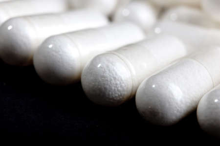 white pills on blackの写真素材