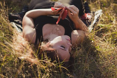 Girl with leaves lying on the grassの写真素材