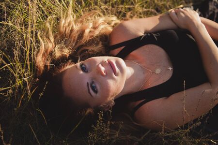 Girl with leaves lying on the grass