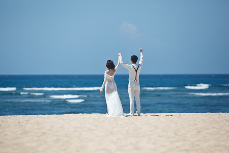 bride and groom couple on the ocean shoreの写真素材