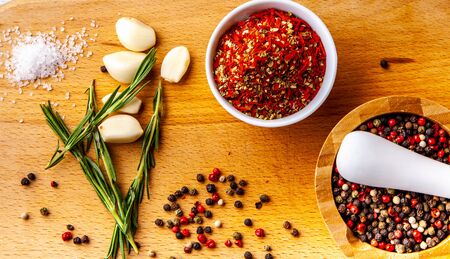 Set of spice chopping on a wooden board: rosemary, garlic, pepper, paprikaの写真素材