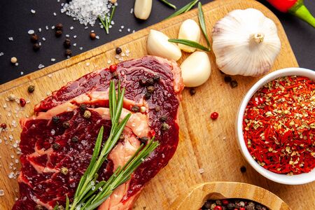 Fresh steak with a set of spices on a cutting boardの写真素材
