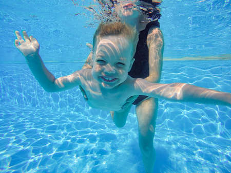 infant is underwater in the pool divingの写真素材