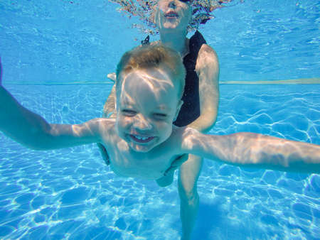 infant is underwater in the pool divingの写真素材