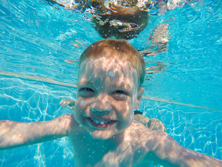 infant is underwater in the pool divingの写真素材