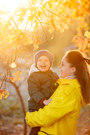 boy with mom in autumn in the leavesの写真素材