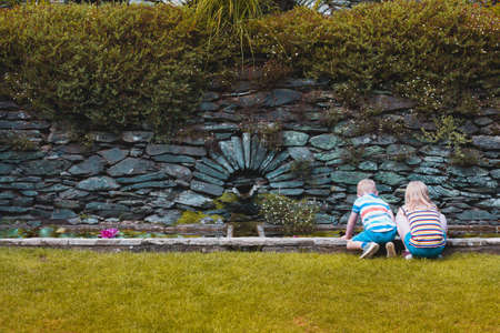 Two children exploring. Boy and Girl children exploring nature searching for wildlife. children playing outdoors looking for wildlife in a pond.の写真素材