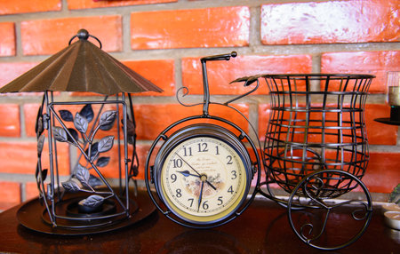 Clock on the table with red brick wall 