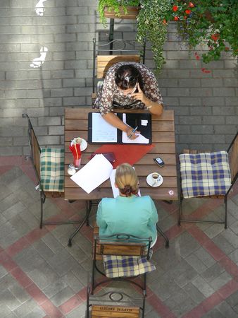 business talks of two ladies in outdoor street cafeの写真素材