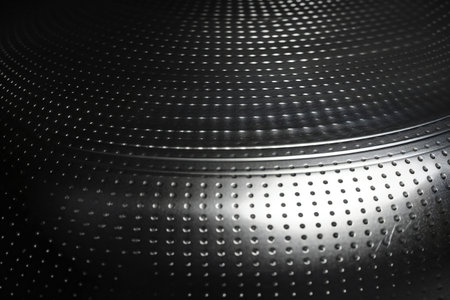 Close-up of a metal perforated drum in black and whiteの素材