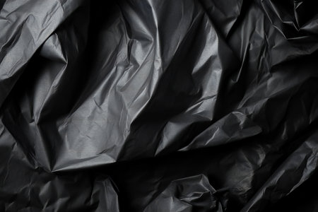 Black crumpled paper as background, closeup. Texture.の素材