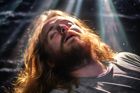 Portrait of a man with long red hair and beard in the rays of lightの素材