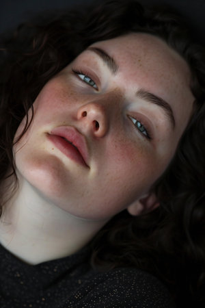 Close-up portrait of a beautiful girl with curly hair and blue eyesの素材