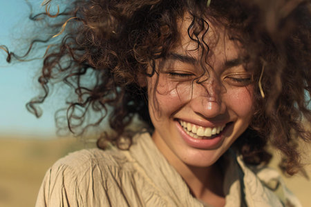 Portrait of a beautiful young woman with curly hair in the countrysideの素材