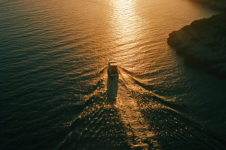 Aerial view of a boat sailing in the sea at sunset.の素材