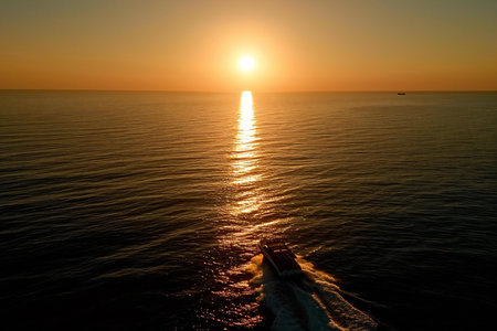Aerial view of beautiful sunset over the sea with boat in the foregroundの素材