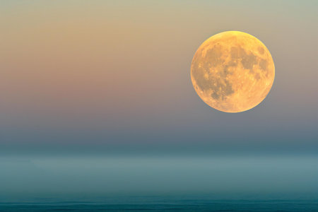 Beautiful full moon over the sea at sunrise. Natural background.の素材