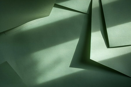 Abstract background of green origami paper sheets with shadow from the windowの素材