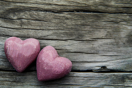 Two pink hearts on old wooden background, valentines day conceptの素材