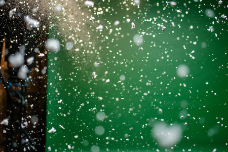 Falling snowflakes with bokeh effect on green backgroundの素材
