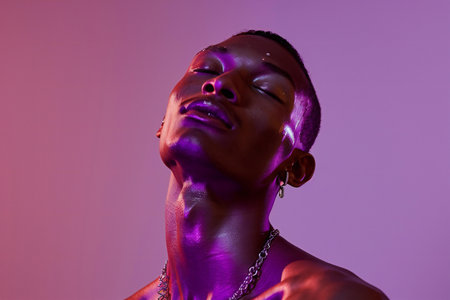 Portrait of a young african american man in neon lightの素材