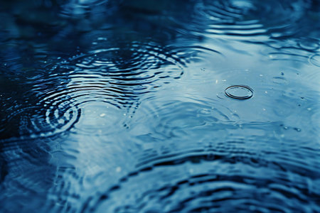 Water drops on the surface of a rippled blue water surfaceの素材