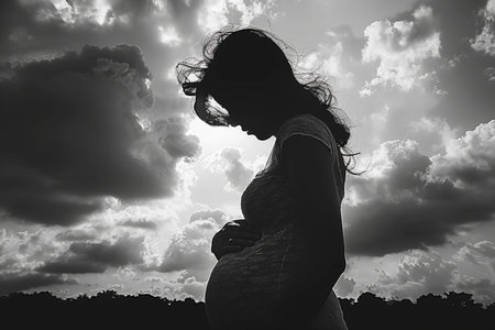 Silhouette of pregnant woman on sky background. Black and whiteの写真素材