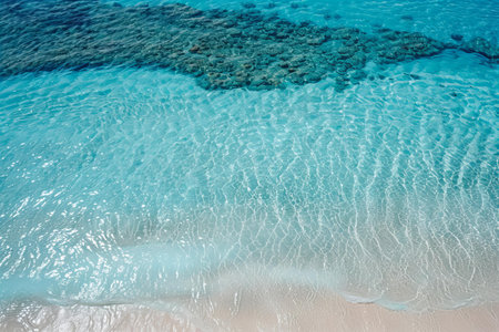 Aerial view of turquoise sea water with coral reef on tropical beach