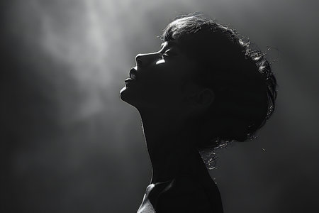 Silhouette of a young woman in a dark roomの写真素材