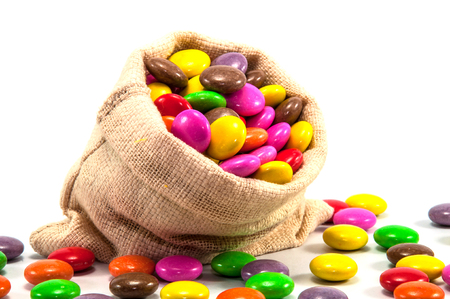 Colorful chocolate candy in mini sack bag on white backgroundの写真素材