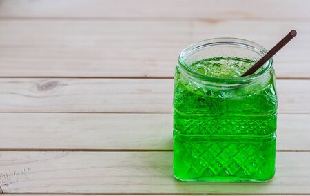 Cold green soda in a big glass over wooden backgroundの写真素材