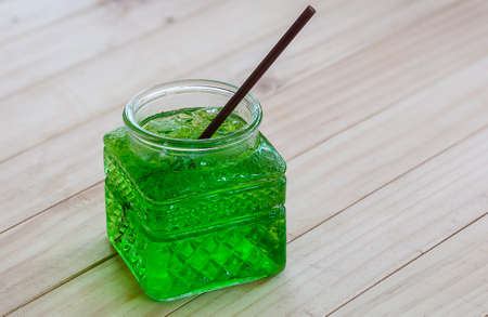 Cold green soda in a big glass over wooden backgroundの写真素材