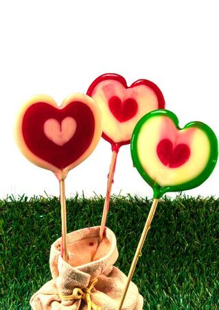 Candy sticks with green grass on white backgroundの写真素材