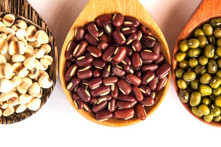 Legumes in a wooden spoon placed on a white backgroundの写真素材