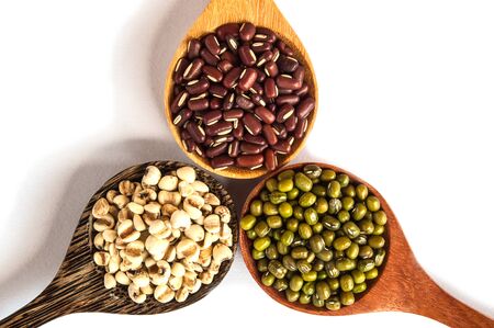 Legumes in a wooden spoon placed on a white backgroundの写真素材