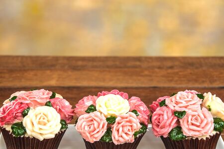 Roses cupcake on wooden floor with multicolor backgroundの写真素材