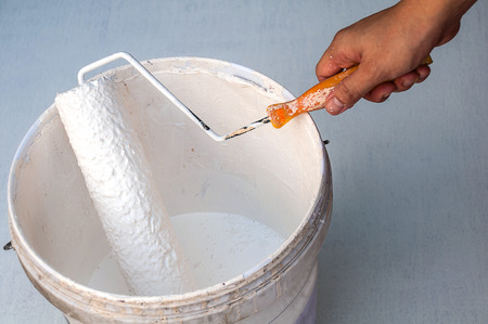 Hand holding rolling paint brush, ready to paintの写真素材