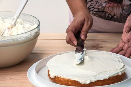 Putting butter  cream cake by hand using spatulaの写真素材