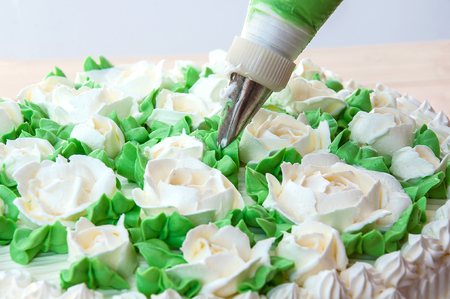 Making rose and leaves from cream for cake decorationの写真素材