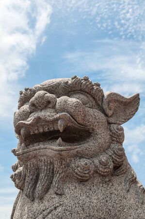 Chinese stone lion over blue sky backgroundの写真素材