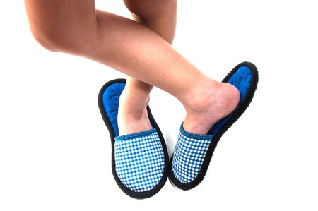Kid's legs standing with indoor handmade soft shoes over white backgroundの写真素材
