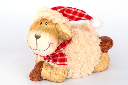 Smiling sheep sitting on white soft cloth as snow isolated over white , Christmas decoration objectの写真素材