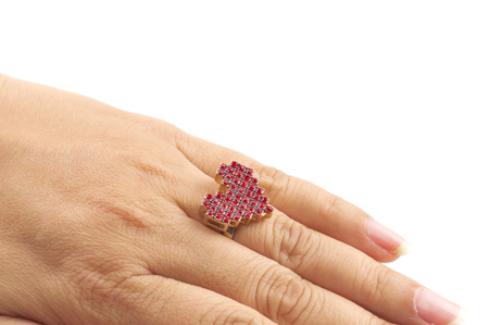 Woman's hand with heart shape ring on her ring finger over white backgroundの写真素材