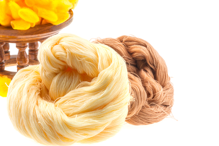Yellow cocoon and yarn over white backgroundの写真素材