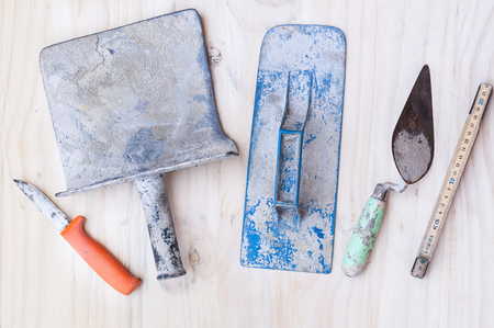 Old construction hand tool over white wooden backgroundの写真素材