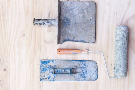 Old construction hand tool over white wooden backgroundの写真素材