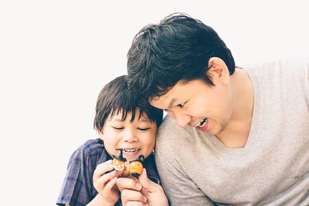Vintage style photo of father is playing Halloween clay with his sonの写真素材