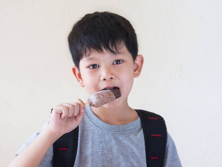 Boy eating ice cream. Photo is focused at his eyes.の写真素材