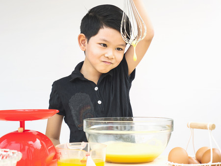 A boy is making cake. Photo is focused at his eyes.の写真素材